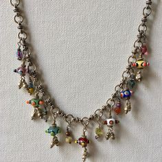 This Charm Necklace has Seven colorful Czech beads that are joined by ten of my treasure charms on a gorgeous hand made Silver Tribal Chain. This Artisan Necklace is whimsical and full of joy! A Boho Tribal Necklace, this beauty makes a bold statement. Treasure charms have beads, crystals, silver and pearls. Necklace measures 16 inches.  One of a kind! Charm Necklace, Silver Charm Necklace, Czech Glass Necklace, Artisan Necklace, Statement Necklace, Boho Necklace, Boho Jewelry Bohemian Sterling Silver Charm Necklace, Multicolor Metal Pendant Charm Necklaces, Whimsical Silver Necklaces With Charms, Whimsical Multicolor Jewelry With Dangling Charms, Artisan Dangle Charms Jewelry, Silver Charm Necklace With Dangling Charms, Unique Metal Necklaces With Dangling Charms, Multicolor Spiritual Charm Necklaces For Gift, Unique Silver Charm Necklace With Dangling Charms