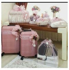 several pieces of luggage sitting on the floor next to a table with flowers and gifts