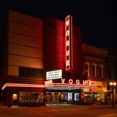 the marquee is lit up at night with red lights on it's sides