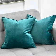 two green velvet pillows on a grey couch