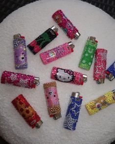 hello kitty lighters are sitting on top of a white cake covered in colorful beads