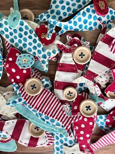 many different colored buttons and ties on a wooden table with polka dot fabric around them