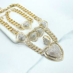 18k Gold Filled Iced Curb Link Chain with CZ Heart Charms Set, Necklace, Bracelet, Earrings & Ring, Wholesale Jewelry Making Supplies.Set Size:Necklace: -Length: 19 inches + 3.3 inches extender | Width: 13mm | Big heart: 47mm x 45mm | Medium Hearts: 26mm x 23mmBracelet:-Length: 8 inches + 3.2 extender | Width: 13mm | Heart: 26mm Earrings: 27mmRing :-Thickness: 4mm | Hand Width: Adjustable | Hand Thickness: 17mm Gold Heart Pendant Jewelry With Bling, Gold Bling Heart Pendant Jewelry, Valentine's Day Gold Rhinestone Jewelry, Valentine's Day Wedding Chain Jewelry, Valentine's Day Wedding Jewelry Chain, Gold Double Heart Crystal Jewelry, Gold Bling Necklaces For Valentine's Day, Gold Bling Necklace For Valentine's Day, Valentine's Day Cubic Zirconia Chain Jewelry