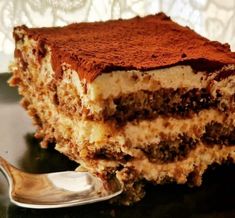 a close up of a piece of cake on a plate with a spoon