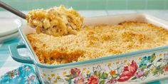 a spoon full of macaroni and cheese being lifted from a casserole dish