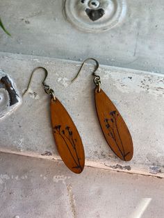 "Leather Prairie Grass Earrings Bringing nature to your earlobe :) Genuine vegetable tanned leather laser engraved with a pine tree and dyed antique brown. Very lightweight and great for everyday wear. ITEM DETAILS - Length: with ear wire: 2.125\" - Width: Approx. 1.5\" - Material: Vegetable Tanned Leather - Hardware: Raw Brass Ear Wire (Nickel and Lead Free for sensitive ears). PLEASE NOTE: with natural materials, each pair of earrings will vary in tone and texture. Please allow for slight variations from picture. This makes each item one-of-a-kind! All purchases come in an Orange and Prairie linen gift bag Find more earrings here: https://www.etsy.com/shop/orangeandprairie?ref=seller-platform-mcnav&section_id=18562705 Find my shop here: https://www.etsy.com/shop/orangeandprairie Use prom Unique Handmade Jewelry Leather, Leather Earrings And Beads, Wood Burn Leather Earrings, Leather Carved Earrings, Beads And Leather Earrings, Tan Leather Earrings, Leather Earrings Tutorial, Nature-inspired Earrings For Everyday, Nature-inspired Everyday Pierced Earrings