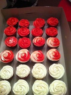 cupcakes with red and white frosting in a box on a table top