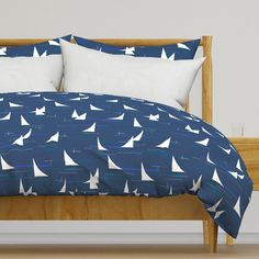 a bed with blue and white sailboats on it