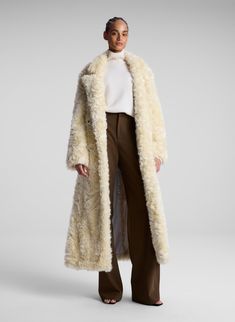 woman wearing cream faux fur coat, white turtleneck sweater and brown pants Cream Fur Coat With Faux Fur Trim For Fall, Cream Fur Coat With Faux Fur Lining For Fall, Cream Faux Fur Trim Coat For Fall, Chic Cream Fur Coat With Faux Fur Lining, Cream Long Fur Coat With Faux Fur Lining, Cream Long Coat With Faux Fur Trim, Luxury Cream Fur Coat With Faux Fur Lining, Cream Faux Fur Outerwear With Fur Trim, Luxury Cream Fur Coat With Faux Fur Trim