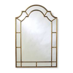 a mirror that is sitting on top of a white wall with gold trimmings