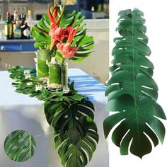 there is a vase with flowers and leaves next to a table that has a plant in it