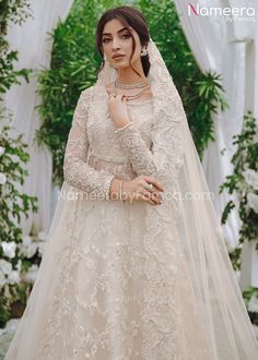 a woman in a wedding dress posing for the camera with her veil draped over her head