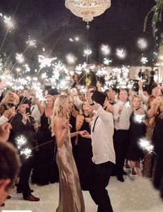 a bride and groom are surrounded by sparklers