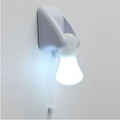 a light that is on the wall next to a white wall with a lamp in it