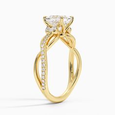 a yellow gold engagement ring with an oval cut diamond in the center and side stones