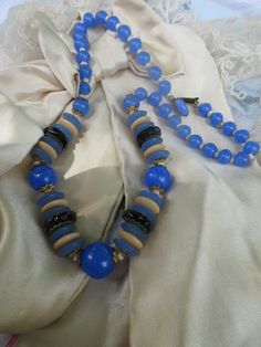 Vintage signed Czech glass beaded necklace. Our signed Czechoslovakia necklace retains it's original jeweled clasp. It's largest center bead measures app. three eighths of an inch. It will adorn your neck at app. 16.25''. It features a combination of blue, black and cream beads. The blue casts a wonderful resemblance to chalcedony. I love the assortment of faceted and flat and round beads with brassy end caps. This circa 1930s necklace exhibits age appropriate wear. I will leave it up to the new 1930s Necklace, Czech Glass Necklace, Puffy Heart Charms, Puffy Heart, Black And Cream, Hand Painted Porcelain, Glass Bead Necklace, Glass Necklace, Czech Glass Beads