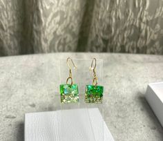 Make a fashion statement with our stunning Lightweight Resin Square earrings. These eye-catching dangle earrings are designed to impress and add a touch of elegance to any outfit. Handmade with love in beautiful British Columbia, our earrings reflect the creativity and craftsmanship that the region is renowned for. Each piece is infused with the spirit of the stunning surroundings, ensuring a touch of elegance and natural beauty. Don't miss out on owning a pair of these Lightweight Resin Square earrings. Treat yourself or surprise a loved one with a thoughtful gift. Elevate your style and showcase your impeccable taste with these exquisite handmade earrings. Note: Due to the handcrafted nature of the earrings, slight variations in color and pattern may occur, making each pair a wearable wo Green Formal Earrings With Ear Wire, Elegant Green Rectangular Earrings, Green Drop Earrings For Anniversary, Modern Green Earrings As Gift, Modern Green Drop Earrings, Hypoallergenic Green Jewelry For Parties, Rectangular Green Earrings Gift, Green Rectangular Earrings As A Gift, Modern Green Earrings For Anniversary