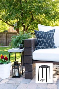 an outdoor seating area with black and white pillows on it, two side tables and one end table