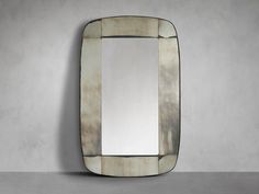 a mirror that is on the wall in front of a gray wall with a white background