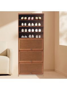 a tall wooden cabinet with drawers in front of a white chair and beige wall behind it