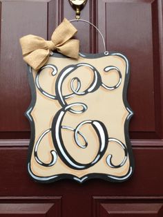 a door hanger with the letter e and a bow on it