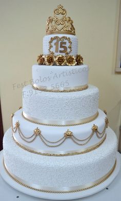 a three tiered white wedding cake with gold decorations on top and the number 13