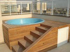 an above ground pool with steps leading up to it and a hot tub in the middle