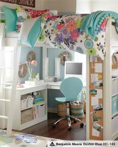 a loft bed with a desk underneath it in a room that has blue walls and wooden floors