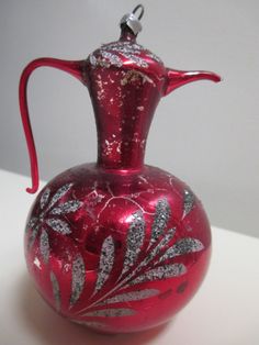 a red glass vase with silver designs on it