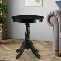 a black table sitting on top of a hard wood floor next to a gray couch