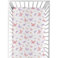 a white crib bed with pink and purple butterflies on the sheet in front of it