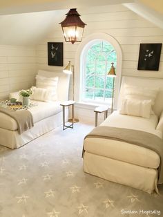 a bedroom with white walls and flooring has two beds in it, one on the other side