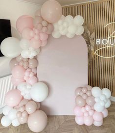 the balloon arch is decorated with pink, white and light pink balloons for a party