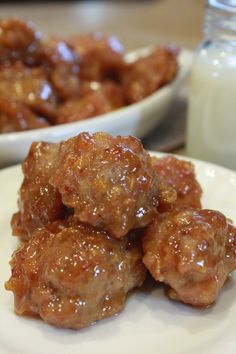 some meatballs on a white plate next to a glass of milk