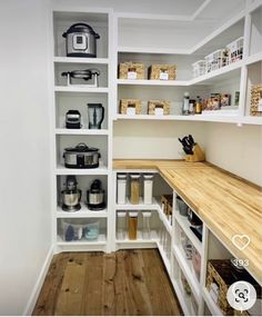 an organized pantry with white shelving and wooden counter tops