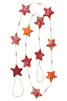 an assortment of red and orange stars hanging from strings