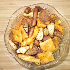 a glass bowl filled with lots of different types of food on top of a wooden table