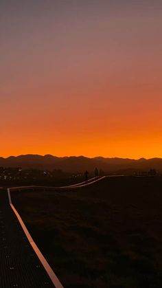 an airplane is flying in the air at sunset or dawn with mountains in the background