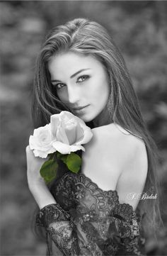 black and white photo of a woman with long hair holding a rose in her hand