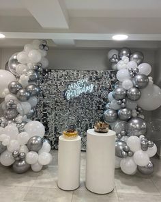 balloons and silver balls are arranged in the shape of an arch for a birthday party