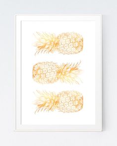 three pineapples are shown on a white wall