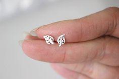 "This listing is for a pair of tiny leaf earrings. For a single stud earring, please visit the section \" One stud \" in my shop www.etsy.com/your/shops/GreatJewelry4All/sections/14235940 These cute studs are measured 5 x 8 mm . They are made of 925 sterling silver ( not silver plated) so they are safe for you if you have an allergy, come with sterling silver butterfly earnuts. Available in Silver The item wil be sent in a gift box. --------------------------------------------------------------- Minimalist Silver Leaf Earrings, Silver Leaf Minimalist Earrings, Silver Leaf-shaped Minimalist Earrings, Tiny White Sterling Silver Earrings, Minimalist Leaf-shaped Sterling Silver Earrings, Minimalist Sterling Silver Leaf-shaped Earrings, Silver Leaf-shaped Earrings For Gift, Silver Leaf-shaped Earrings Gift, Dainty Tiny Silver Cartilage Earrings