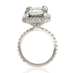 a white gold ring with an oval cut diamond and pave set shoulders