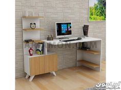 a computer desk with a monitor, keyboard and mouse in front of a brick wall