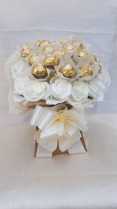 a vase filled with white flowers and chocolates