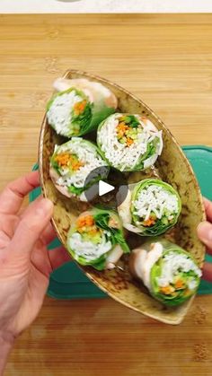 a person is holding up some food on a platter with chopsticks in it