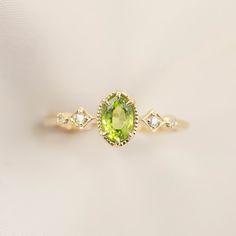 * ≈6x4mm oval peridot * Band width: ≈1.3mm * G color SI diamonds, ≈0.04ctw * Setting style: Prong setting, low profile (sits flush on your finger) * Material: Solid 14k yellow gold, rose gold or white gold * Made of 100% recycled precious metal and ethically sourced gemstone * Comes in a gift box with a bow ready for gifting * Handmade with love and great care in New York * Please note that colors may vary slightly as they are genuine gemstones. Our Dedication All our jewelry is designed and cre Peridot Birthstone Diamond Ring Fine Jewelry, Fine Jewelry Peridot Birthstone Ring With Center Stone, Peridot Gemstone Diamond Ring, Lime Green Peridot Rings In Fine Jewelry Style, Lime Green Peridot Ring For May Birthstone, Lime Green Peridot Birthstone Ring For May, Lime Green Peridot Rings Fine Jewelry, Lime Green Peridot Birthstone Ring, Green Peridot Birthstone Ring, Dainty Style