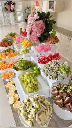 a table filled with lots of different types of food on plates and serving trays