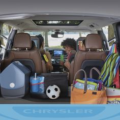 a woman sitting in the back seat of a car with lots of luggage on it