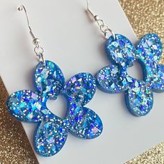 the blue earrings are decorated with glitters and bowknots on it's ear wires